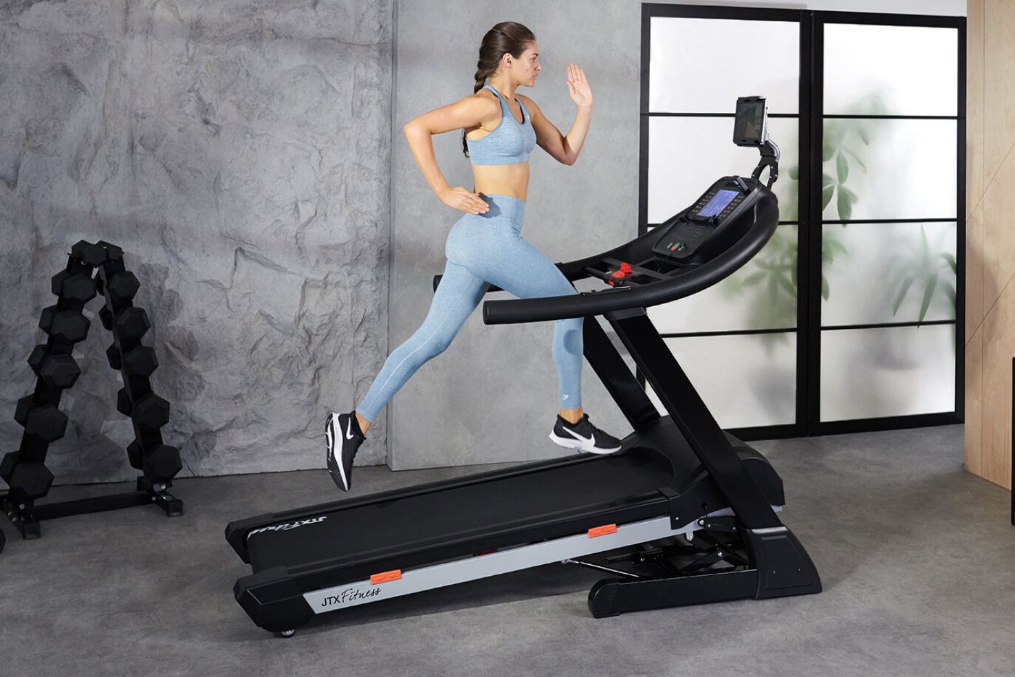 Woman demonstrating a new treadmill.