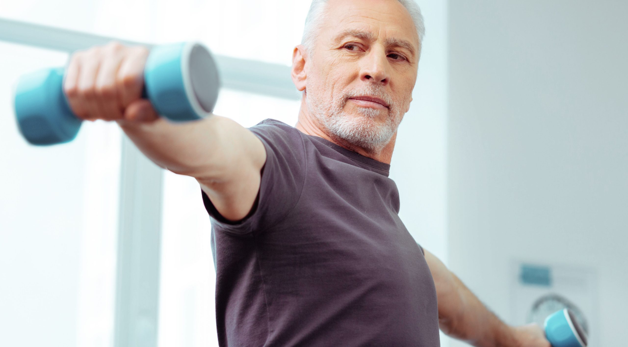 Man with dumbbell with declining muscle tone.