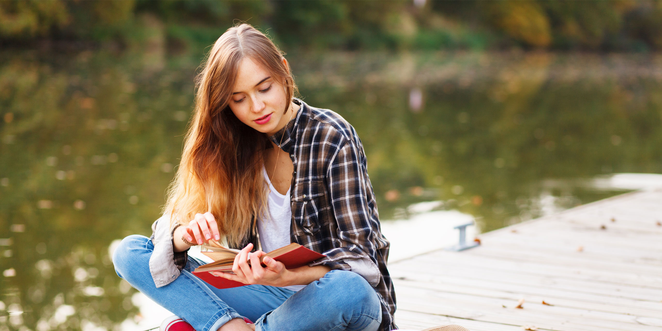 Young teen reading a book.