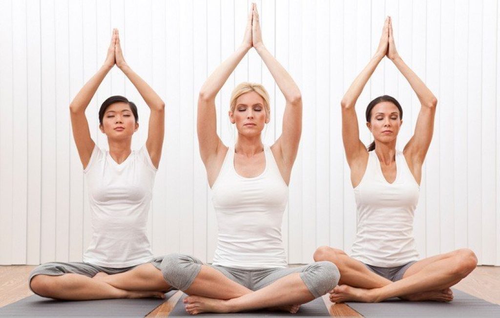 Group of women doing yoga poses.