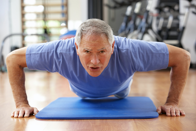 Older man exercising doing push-ups.