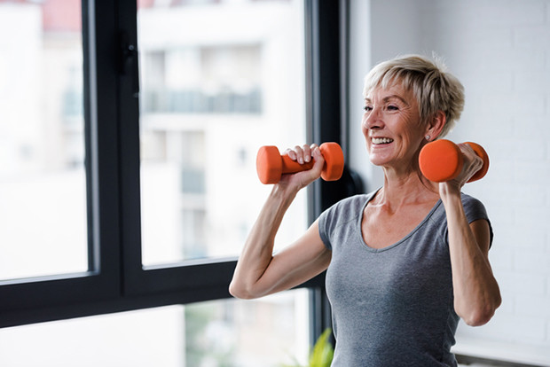 Older woman doing strength training with dumbbells.