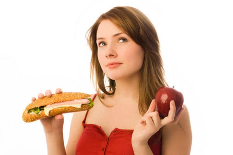 Woman trying to decide a healthy choice of foods.