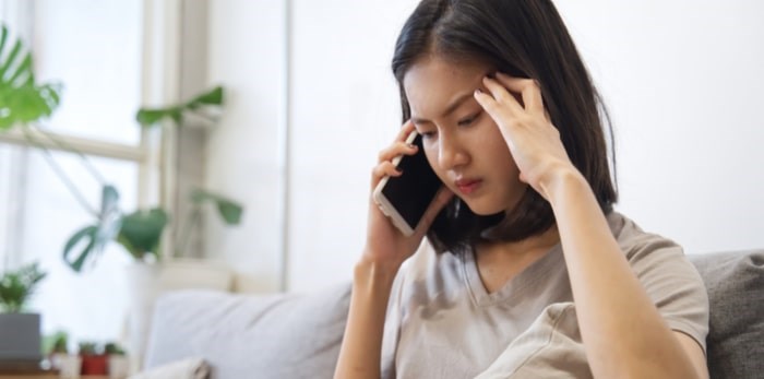 Woman on the phone feeling stress.