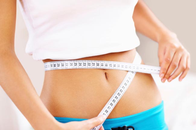 Woman measuring her waist size.