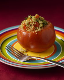 A Quinoa stuffed tomato on a plate.