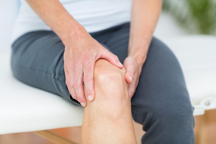 Man holding his knee with suspected tendiniitis.