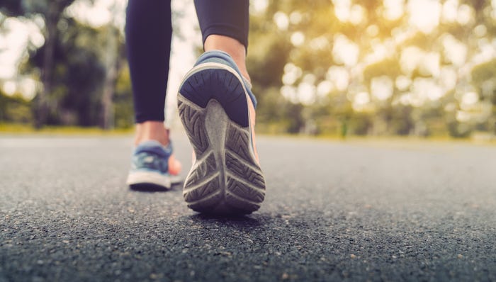 Woman walking for exercise on a trail.