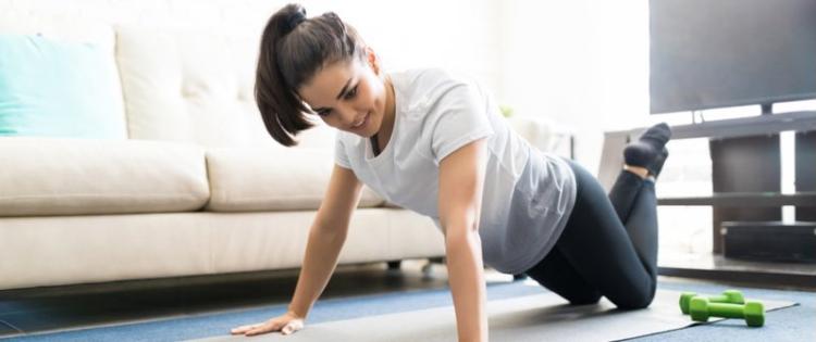 Young women exercising on the floor at home.