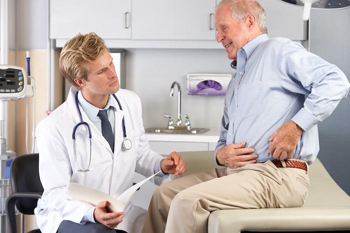 Man with back pain talking to his doctor.
