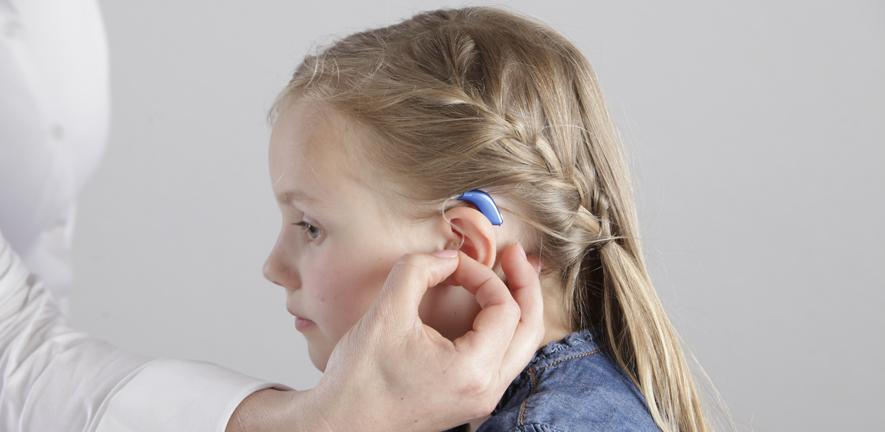 Child being fitted with a hearing aid.