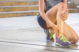 Young womaan with her hand on her shin.